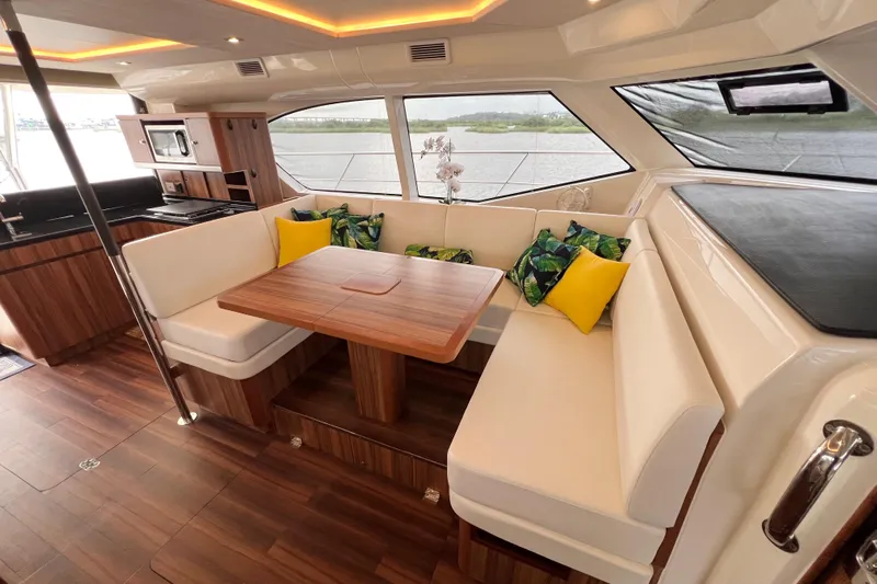 Tonga Time Yacht Photos Pics Luxurious interior of 2019 Aquila 44 yacht with elegant dining area and scenic window views.