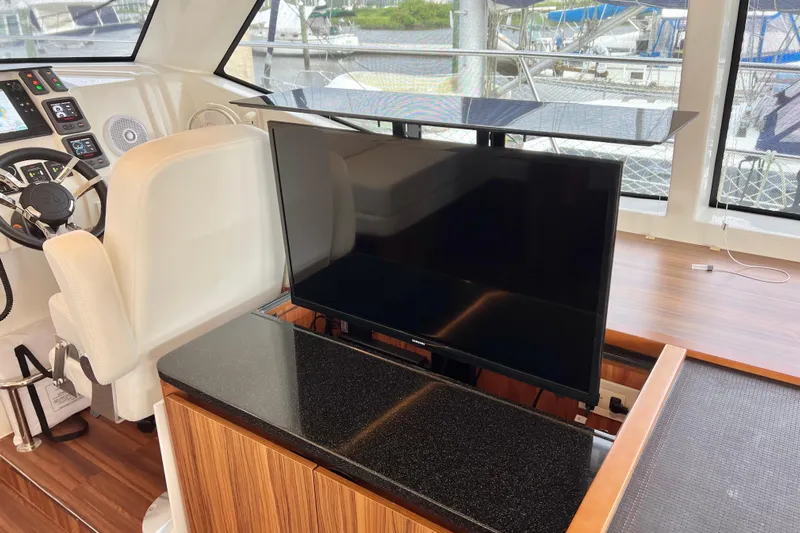 Tonga Time Yacht Photos Pics Interior of 2019 Aquila 44 yacht with helm, TV, and modern controls.