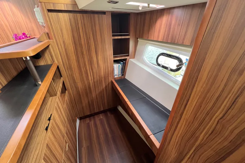Tonga Time Yacht Photos Pics Luxurious wood interior of 2019 Aquila 44 yacht with seating and window view.