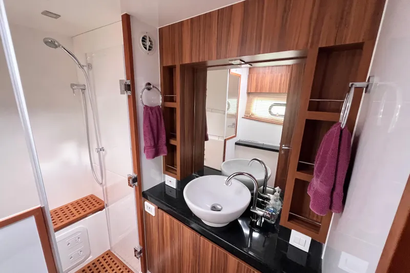 Tonga Time Yacht Photos Pics Luxurious bathroom in 2019 Aquila 44 yacht with modern fixtures and wooden accents.