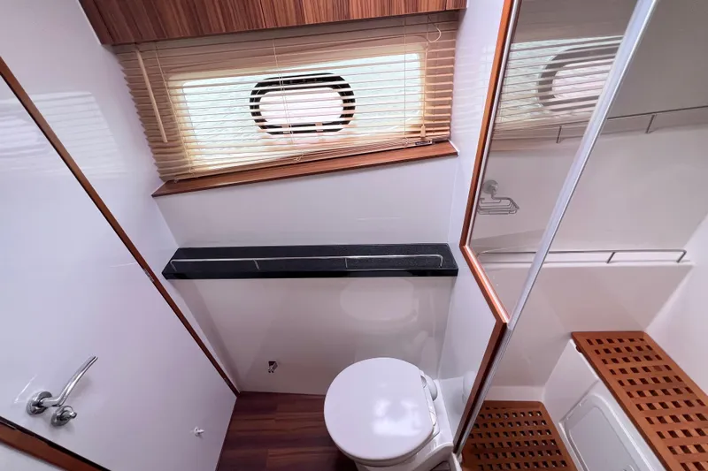 Tonga Time Yacht Photos Pics Bathroom interior of 2019 Aquila 44 yacht with wooden accents and modern fixtures.