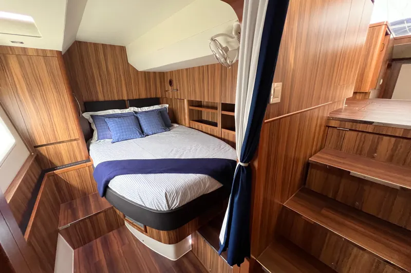 Tonga Time Yacht Photos Pics Luxurious cabin interior of 2019 Aquila 44 yacht with wood paneling and cozy bedding.