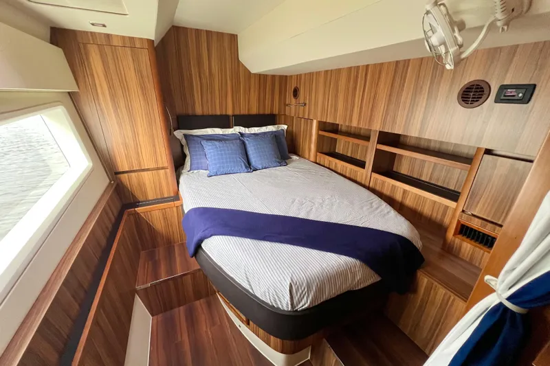 Tonga Time Yacht Photos Pics Luxurious 2019 Aquila 44 yacht cabin with wood paneling and cozy bedding.