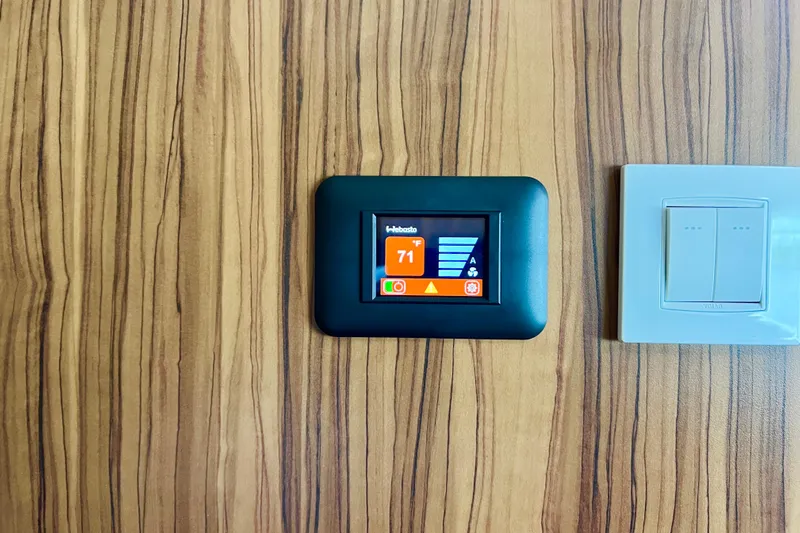 Tonga Time Yacht Photos Pics Thermostat and light switch on wood panel, Aquila 44, 2019 model.