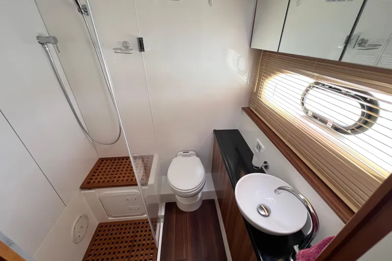 Tonga Time Yacht Photos Pics Luxurious 2019 Aquila 44 yacht bathroom with shower, toilet, and sink, featuring modern design elements.
