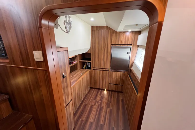 Tonga Time Yacht Photos Pics Luxurious wood-finished interior of 2019 Aquila 44 yacht, featuring modern cabinetry and lighting.