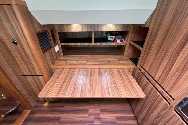 Tonga Time Yacht Photos Pics Luxurious wood interior of 2019 Aquila 44 yacht with foldable desk and storage.