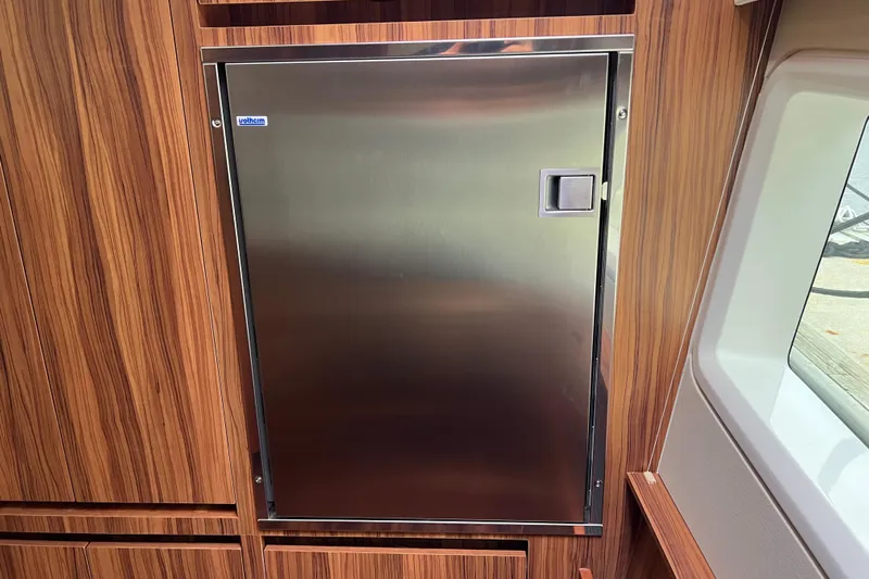 Tonga Time Yacht Photos Pics Stainless steel door on 2019 Aquila 44 yacht, surrounded by wood paneling.