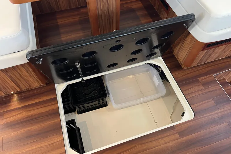 Tonga Time Yacht Photos Pics Storage compartment on Aquila 44 yacht, 2019 model, with open hatch and wooden flooring.