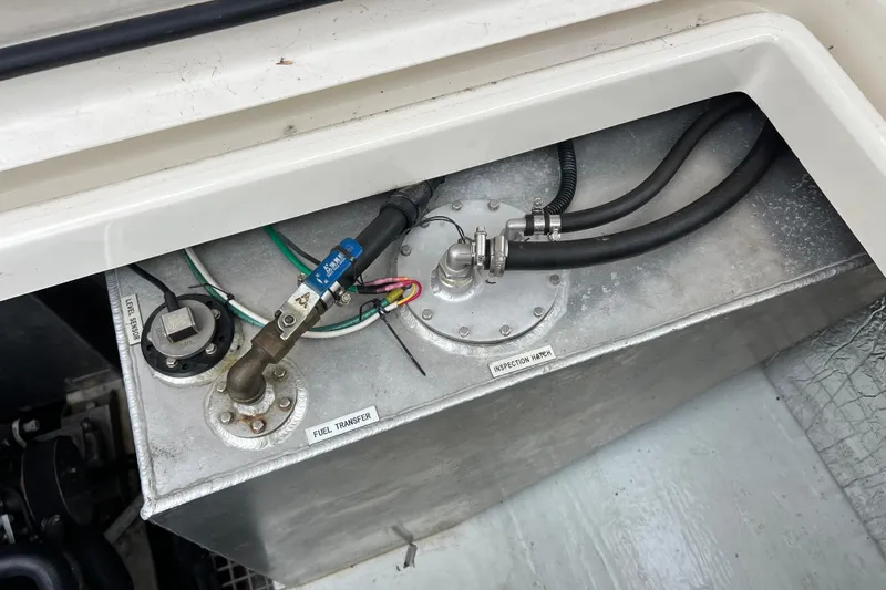 Tonga Time Yacht Photos Pics Fuel transfer system in a 2019 Aquila 44 boat, showing inspection hatch and connections.