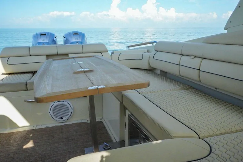  Yacht Photos Pics 2019 Chris-Craft Launch 35 GT OB interior with beige seating and wooden table on calm water.