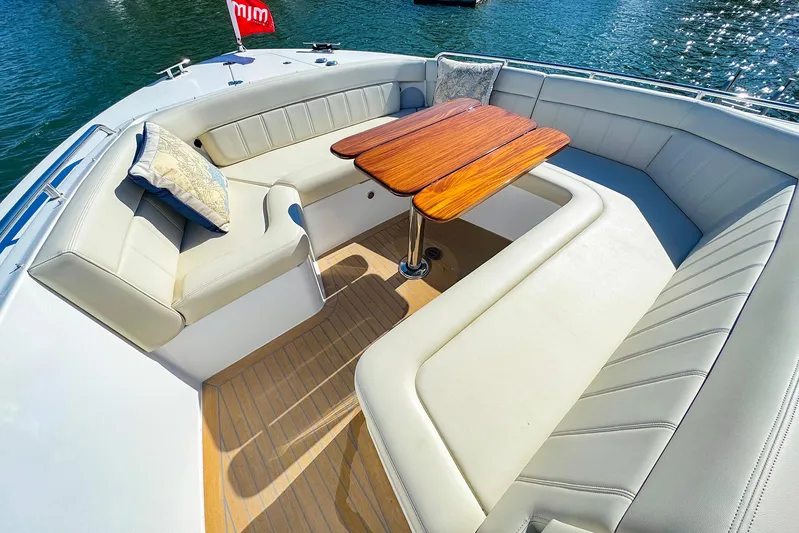 4794tw Yacht Photos Pics Luxurious seating area on 2024 MJM 4 boat with wooden table and cushions.
