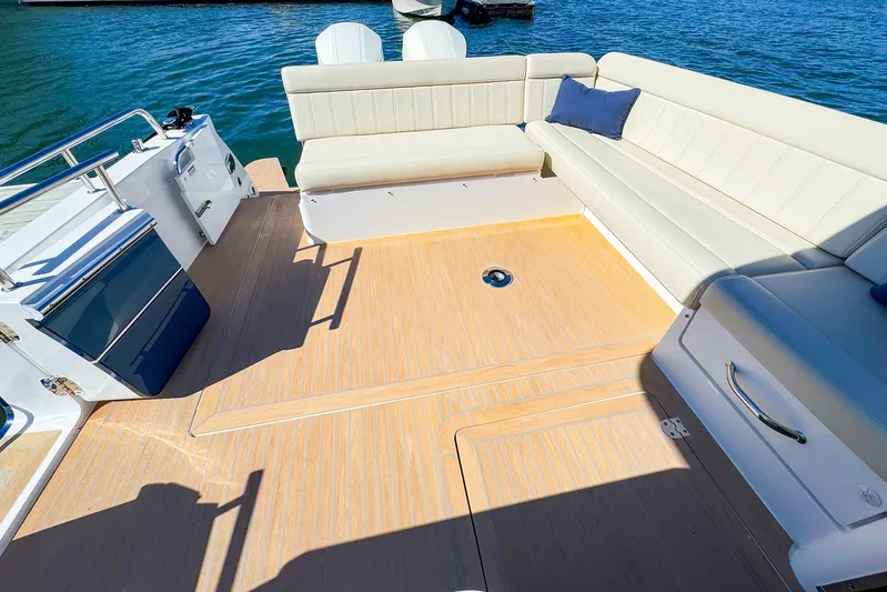 4794tw Yacht Photos Pics 2024 MJM 4 boat deck with beige seating and blue cushion on water.