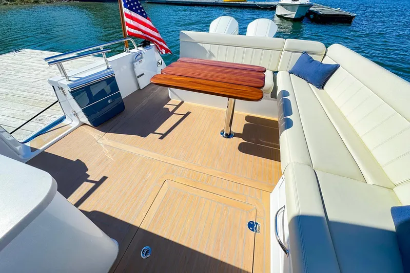 4794tw Yacht Photos Pics Luxurious 2024 MJM 4 boat deck with seating, table, and American flag.