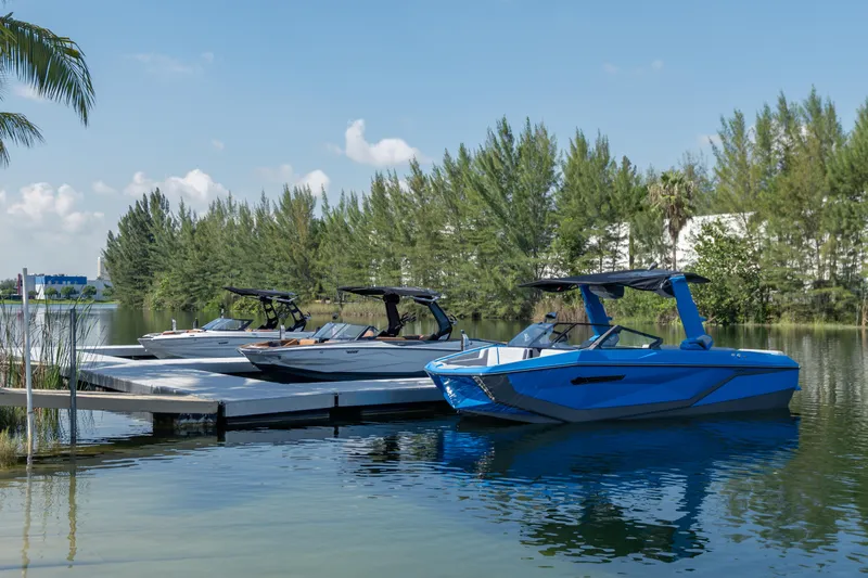  Yacht Photos Pics 2026 Nautique Super Air Nautique G23 boats docked on a serene lake.
