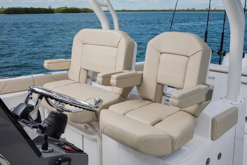 Amuninni Yacht Photos Pics Manufacturer Provided Image: 2021 Pursuit S 328 Sport boat with beige captain seats and ocean backdrop.