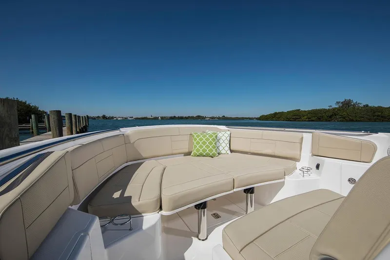 Amuninni Yacht Photos Pics Manufacturer Provided Image: 2021 Pursuit S 328 Sport boat with beige seating and green cushion on the water.