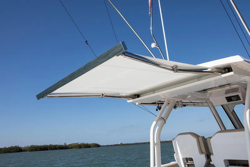 Amuninni Yacht Photos Pics Manufacturer Provided Image: 2021 Pursuit S 328 Sport boat with extended sunshade over water.