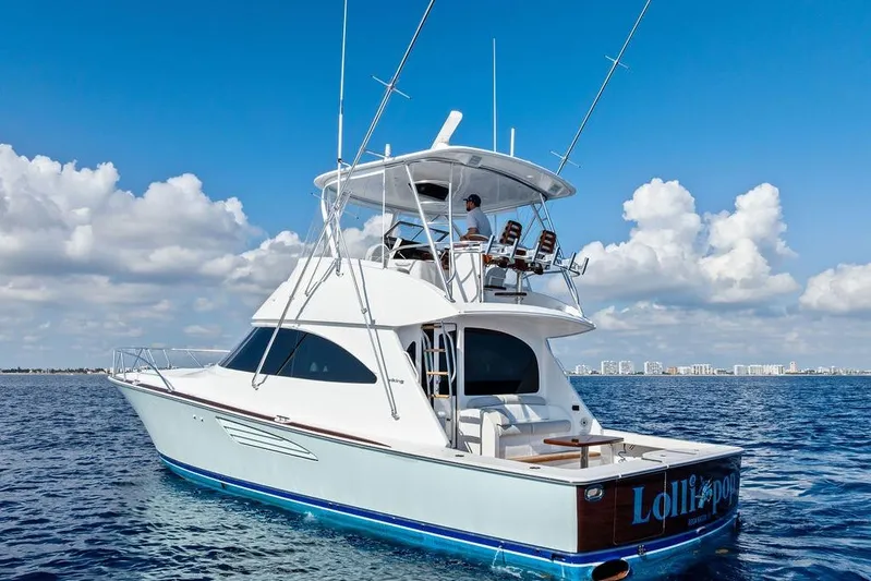 Lollipop Yacht Photos Pics 2022 Viking 48 Convertible yacht cruising on open water under a clear blue sky.