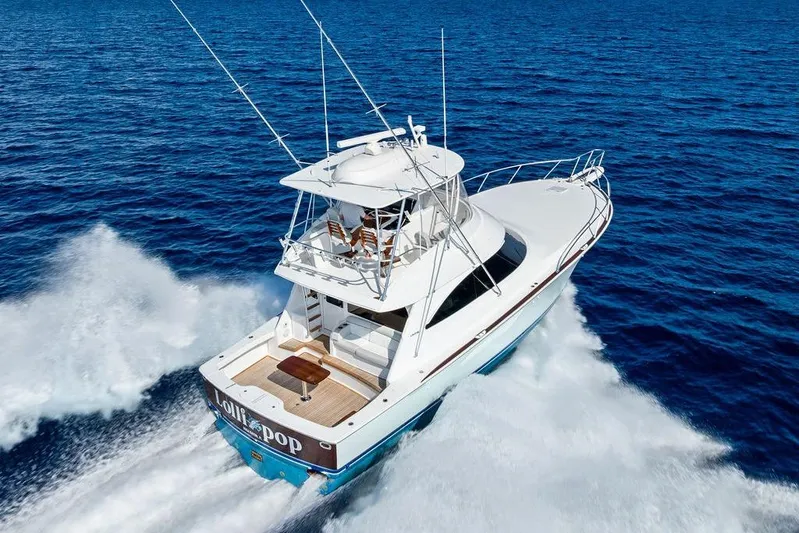 Lollipop Yacht Photos Pics 2022 Viking 48 Convertible yacht cruising on open blue ocean waters.