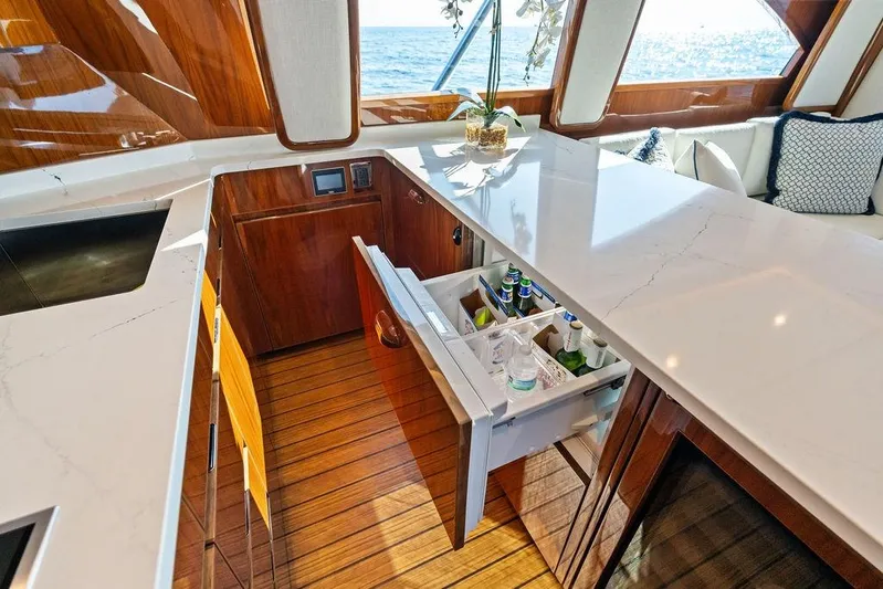 Lollipop Yacht Photos Pics Luxurious 2022 Viking 48 Convertible yacht interior with open drawer fridge and elegant wood finish.