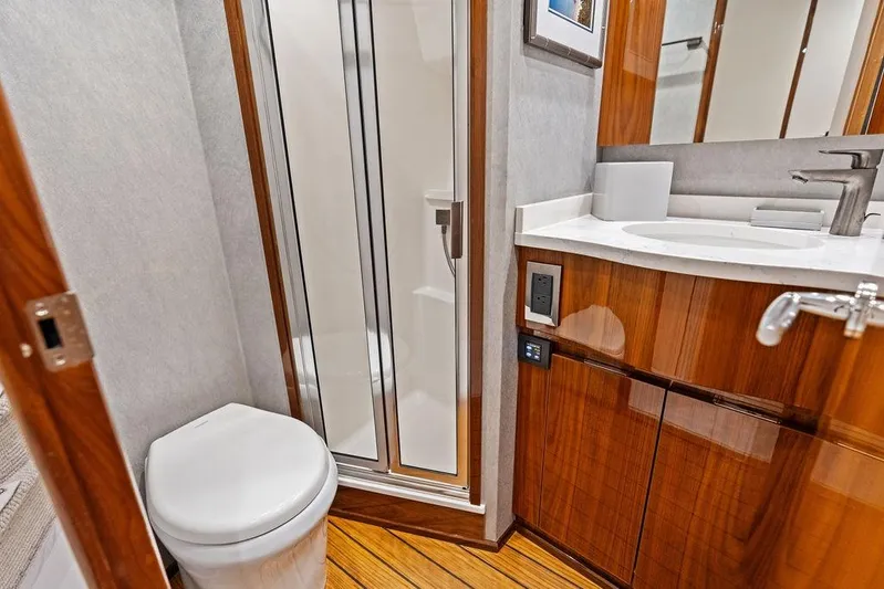 Lollipop Yacht Photos Pics Luxurious bathroom in 2022 Viking 48 Convertible yacht with modern fixtures and wood accents.