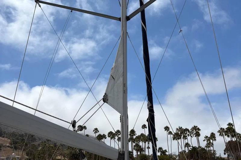 Kokua Yacht Photos Pics Mast and rigging of a 2004 Hunter 33 sailboat against a blue sky with palm trees.
