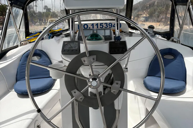 Kokua Yacht Photos Pics Steering wheel of a 2004 Hunter 33 sailboat with navigation instruments and seating.