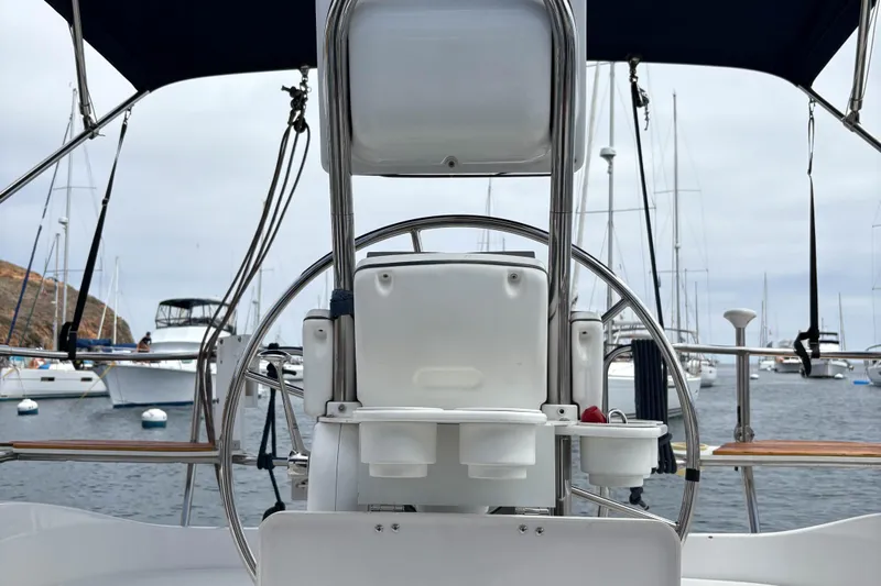 Kokua Yacht Photos Pics Steering wheel of a 2004 Hunter 33 sailboat in a marina setting.