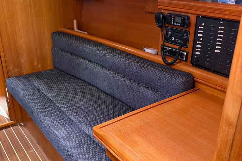 Kokua Yacht Photos Pics Interior of 2004 Hunter 33 sailboat with cushioned seating and control panel.