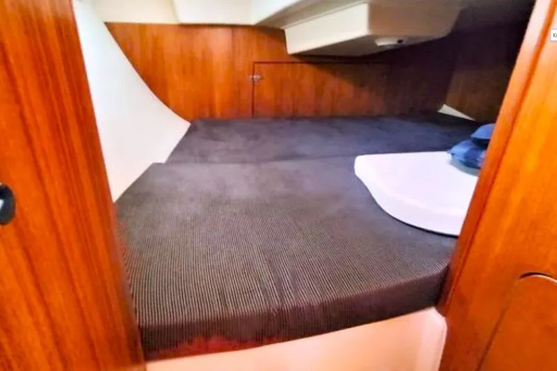 Kokua Yacht Photos Pics Cozy cabin interior of 2004 Hunter 33 sailboat with wooden paneling and comfortable bedding.