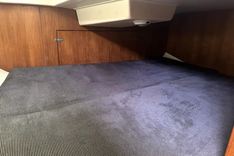 Kokua Yacht Photos Pics Interior cabin of a 2004 Hunter 33 sailboat with wooden walls and blue carpet.