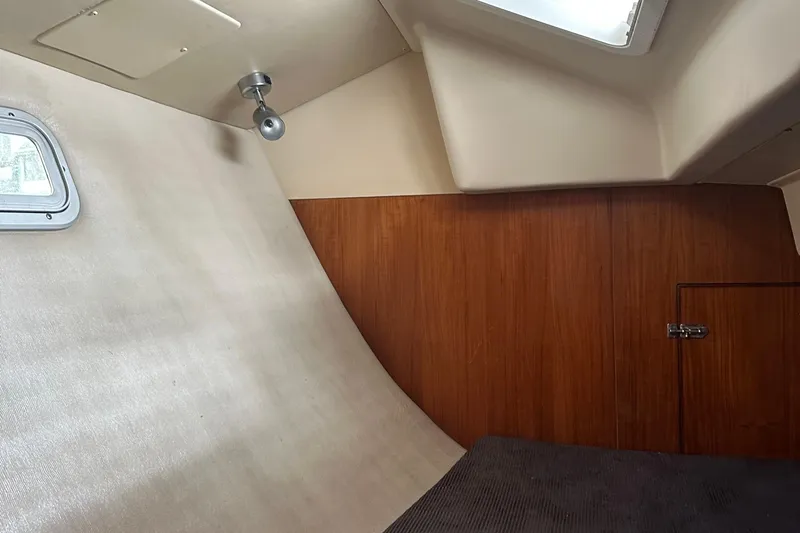 Kokua Yacht Photos Pics Interior cabin of a 2004 Hunter 33 sailboat with wood paneling and a small window.