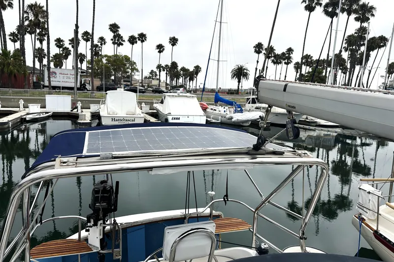 Kokua Yacht Photos Pics 2004 Hunter 33 sailboat with solar panel docked in marina, surrounded by palm trees.