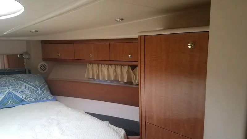 Instant Karma Yacht Photos Pics Interior cabin of 2002 Maxum 4200 SY yacht with wood cabinets and cozy bedding.