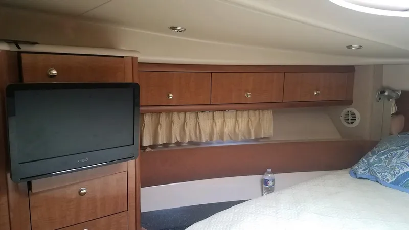 Instant Karma Yacht Photos Pics Maxum 4200 SY 2002 yacht interior with TV, wood cabinets, and bed.