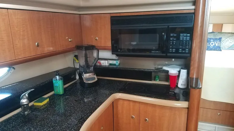 Instant Karma Yacht Photos Pics 2002 Maxum 4200 SY yacht kitchen with wood cabinets and black countertops.