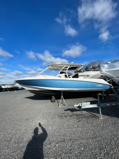  Yacht Photos Pics 2011 Boston Whaler 320 Outrage Cuddy Cabin on gravel lot under blue sky.
