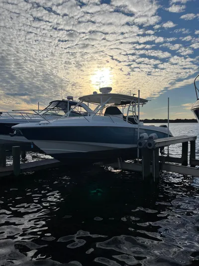  Yacht Photos Pics 2011 Boston Whaler 320 Outrage Cuddy Cabin docked at sunset.