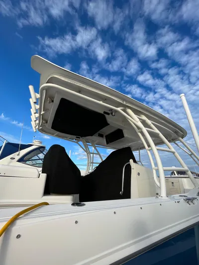  Yacht Photos Pics 2011 Boston Whaler 320 Outrage Cuddy Cabin with sleek design under a blue sky.