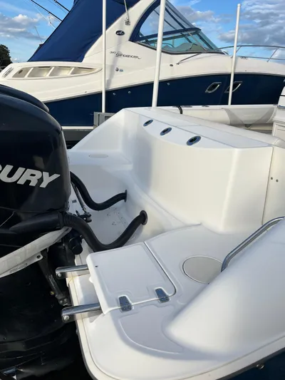  Yacht Photos Pics 2011 Boston Whaler 320 Outrage Cuddy Cabin with Mercury outboard engine, docked beside another boat.