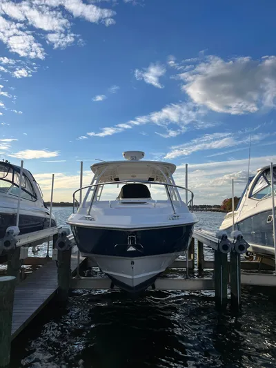  Yacht Photos Pics 2011 Boston Whaler 320 Outrage Cuddy Cabin docked under a blue sky.
