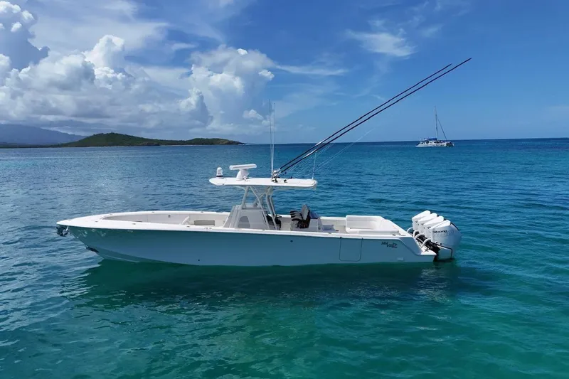  Yacht Photos Pics 2022 SeaVee 390Z boat on clear blue ocean with distant island and sailboat.