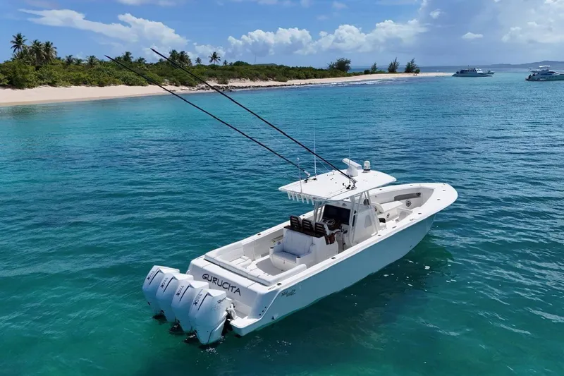  Yacht Photos Pics 2022 SeaVee 390Z boat anchored in clear turquoise waters near a tropical island.
