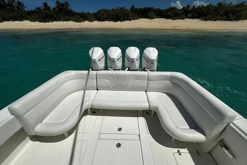  Yacht Photos Pics 2022 SeaVee 390Z boat with quad engines, white seating, near tropical beach.
