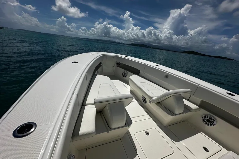  Yacht Photos Pics 2022 SeaVee 390Z boat interior with seating, on calm ocean waters under cloudy sky.