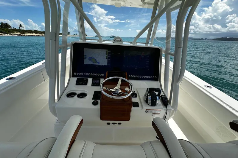  Yacht Photos Pics 2022 SeaVee 390Z boat helm with navigation screens, steering wheel, and ocean view.
