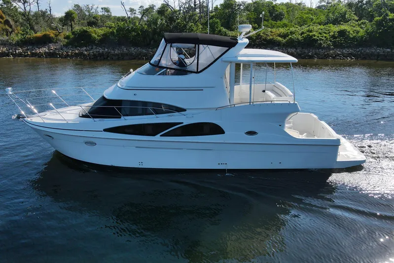 Aloha Spirit Yacht Photos Pics 2005 Carver 41 Cockpit Motor Yacht cruising on calm water, surrounded by lush greenery.