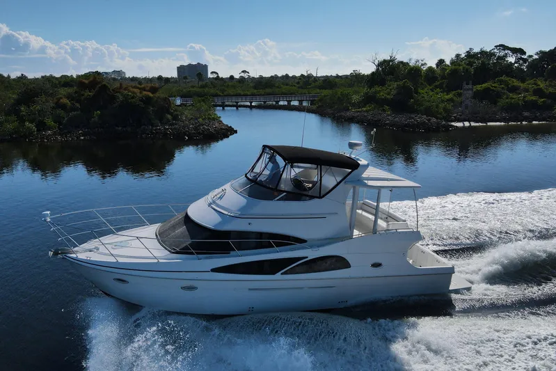 Aloha Spirit Yacht Photos Pics 2005 Carver 41 Cockpit Motor Yacht cruising on a serene waterway.