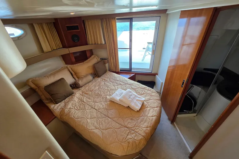 Aloha Spirit Yacht Photos Pics Luxurious bedroom in 2005 Carver 41 Cockpit Motor Yacht with cozy bedding and ocean view.
